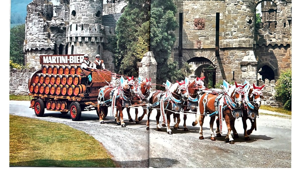 Gespann mit Martini-Bier-Wagen vor historischen Mauern
